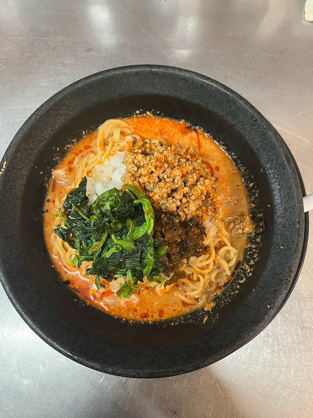 真上から見た担々麺。青菜と肉みそ、渦を巻く濃厚スープ